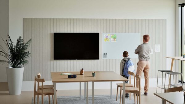 Leerlingen schrijven op een whiteboardwand in een modern klaslokaal, Chameleon whiteboardwand met akoestische panelen in een leerplein, Docent gebruikt wandvullend whiteboard bij interactieve les, Overzicht van een klas met whiteboardwand en rustige inrichting, Detail van ceramic steel schrijfoppervlak met leerlingentekening.